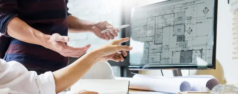 Designer reviewing a 3D office layout on screen with a client