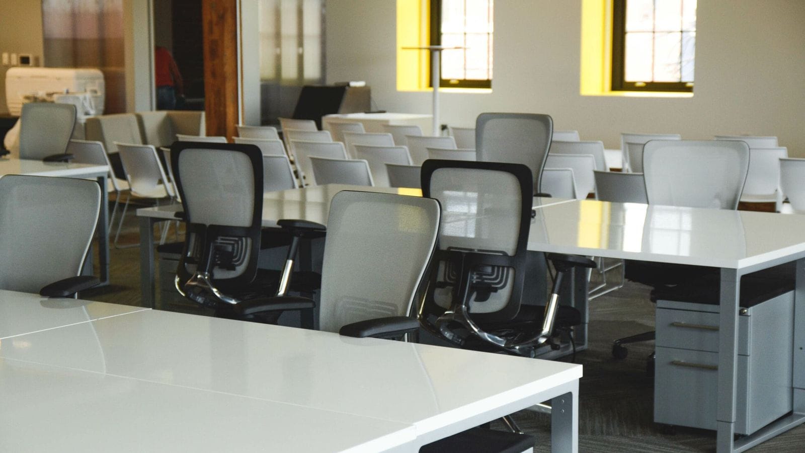 Ergonomic mesh task chairs with adjustable arms lined up in an open workspace