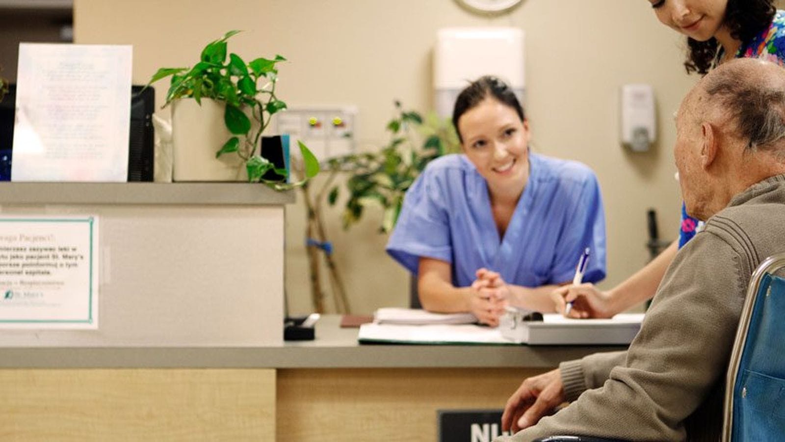 Accessible height reception counter where staff assist a patient using a wheelchair