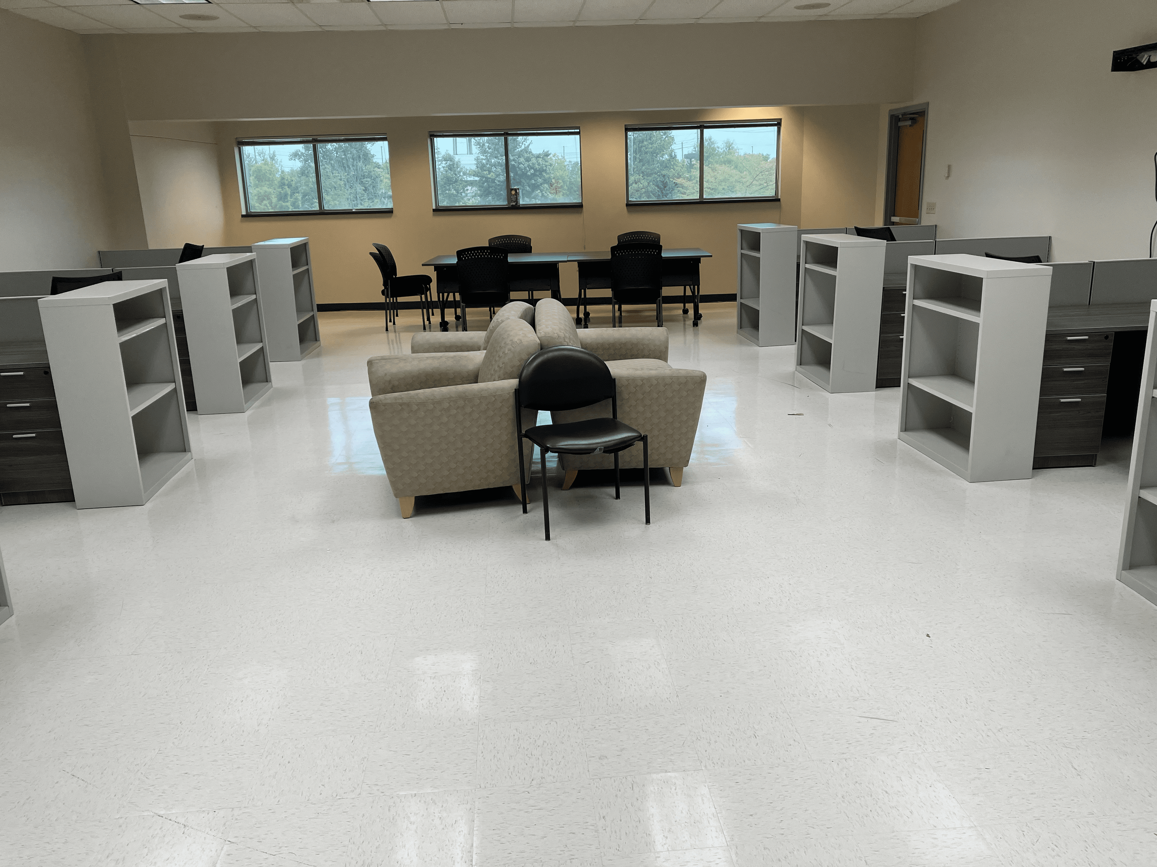 Open office with lounge chairs, a conference table, and bookcases.