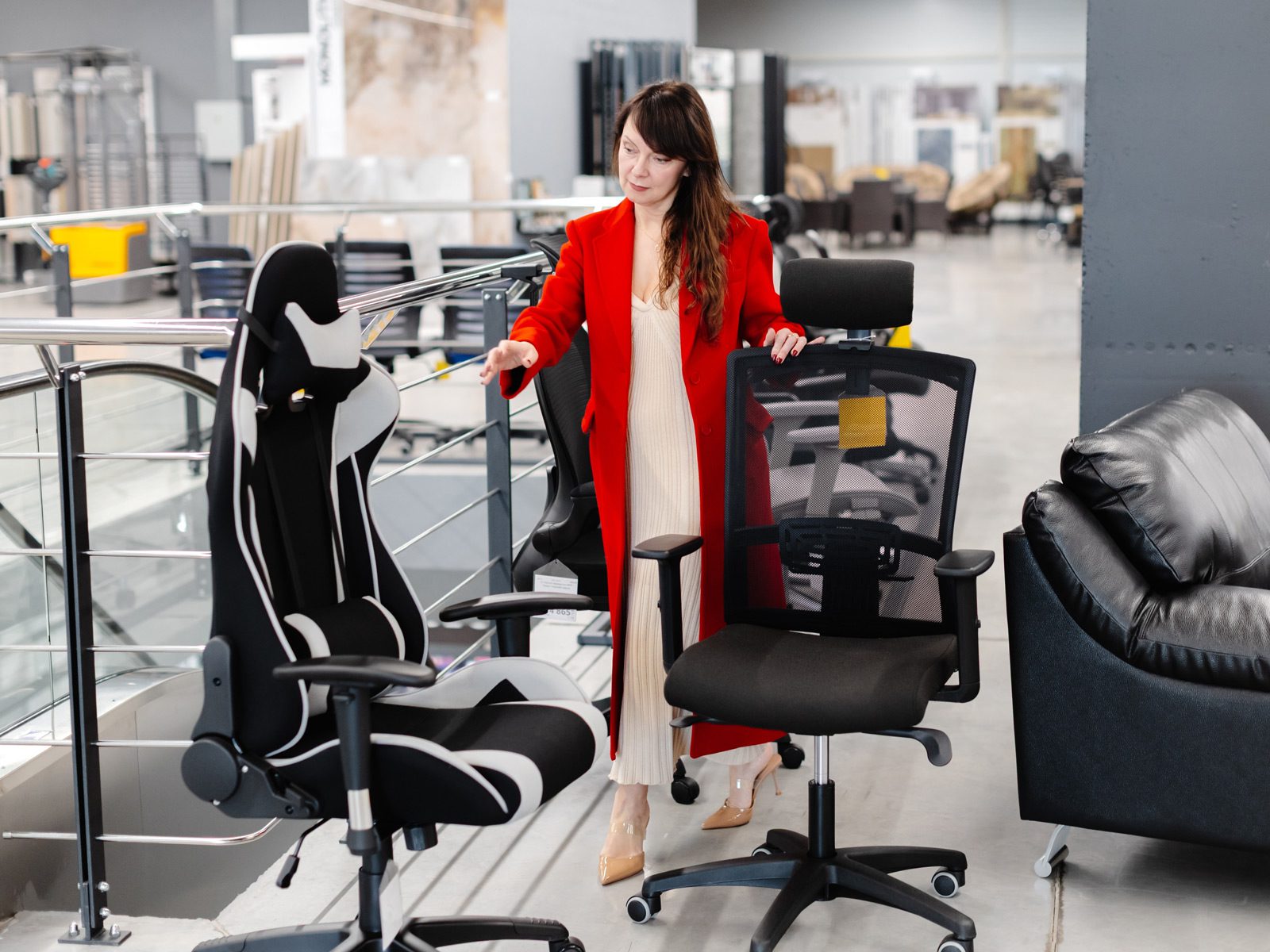 An executive looks at two new office chairs to buy.